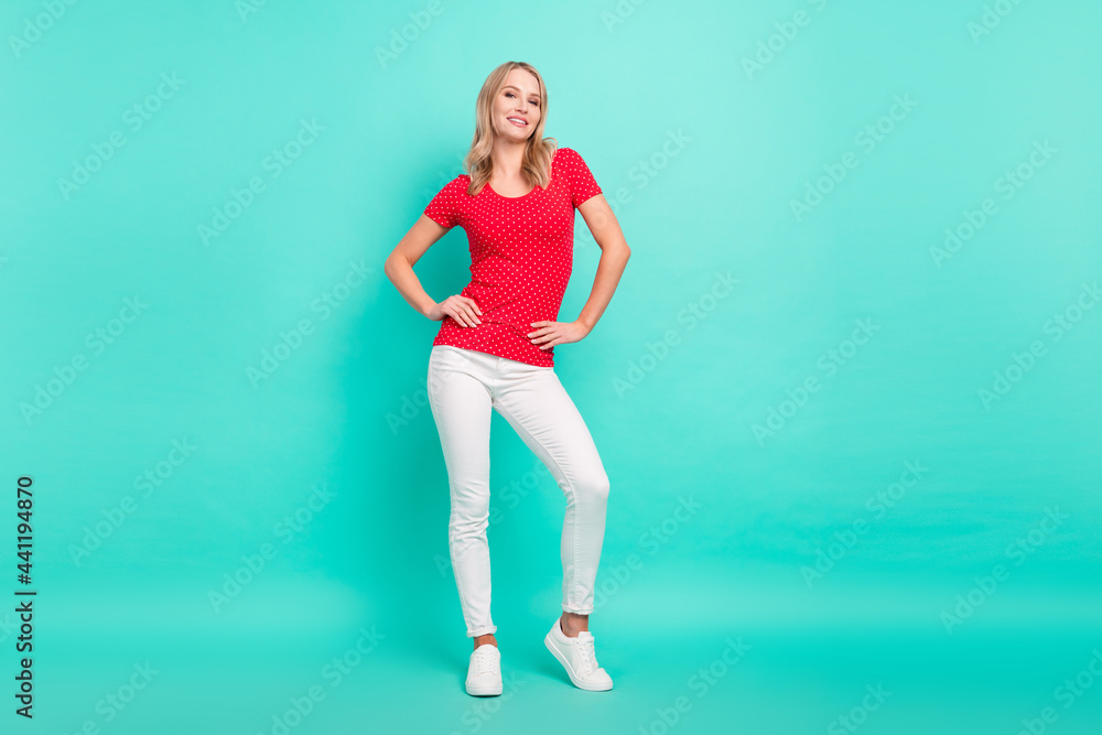Full size photo of young attractive pretty woman happy positive smile hands on waist confident isolated over teal color background