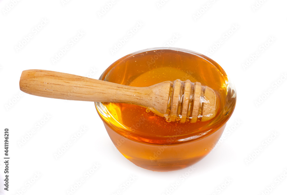 Natural honey over a clear glass isolated on white Background Ingredients for cooking Natural honey over a clear glass isolated on white Background Ingredients for cooking