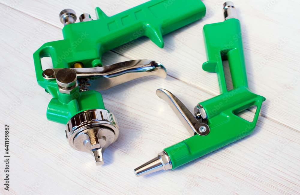 Green air compressor gun. Isolated on a wooden background Green air compressor gun. Isolated on a wooden background