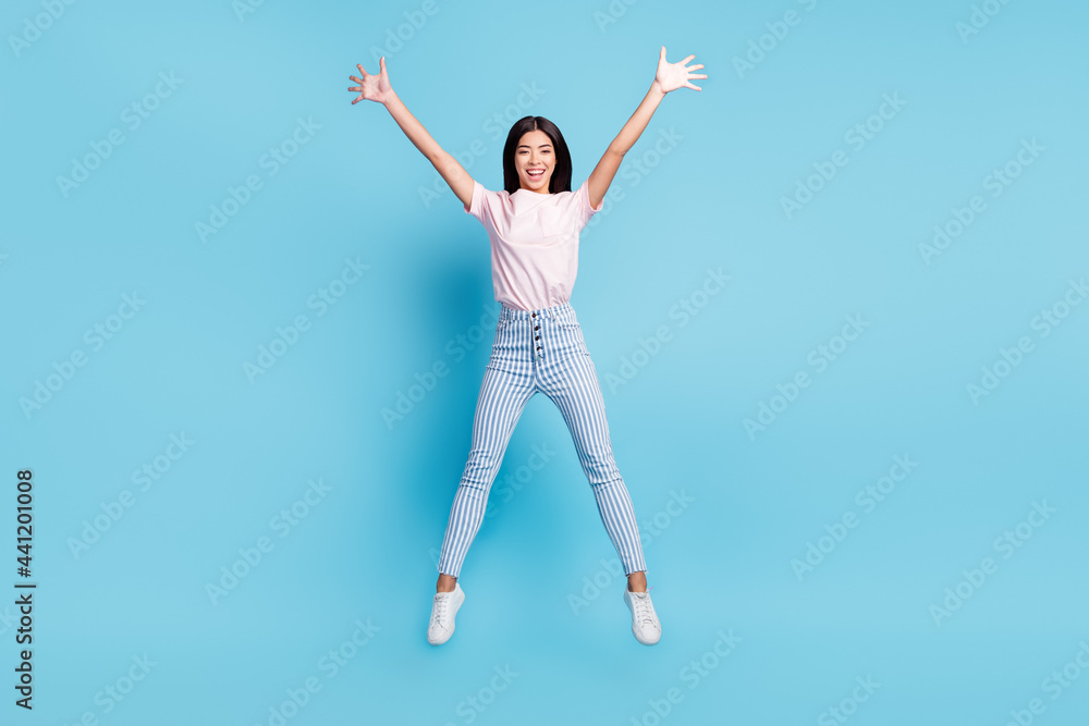 Full size photo of young cheerful girl happy positive smile active jump up isolated over blue color background