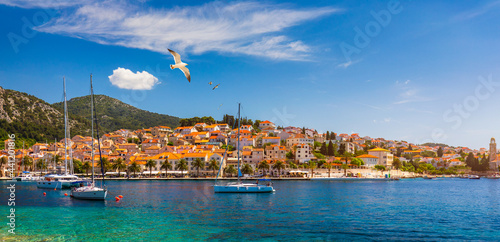 Hvar town with seagull's flying over city, famous luxury travel destination in Croatia. Boats on Hvar island, one of the many Islands near Dubrovnik and Korcula on the Dalmatian Coast of Croatia.