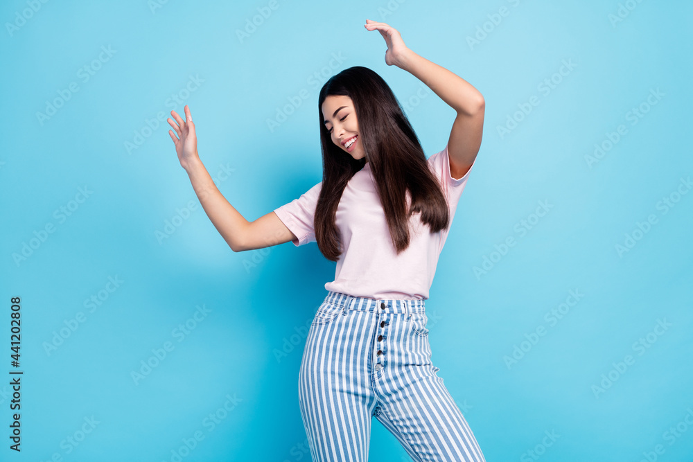 Naklejka premium Photo of young excited girl happy positive smile enjoy music dance party isolated over blue color background