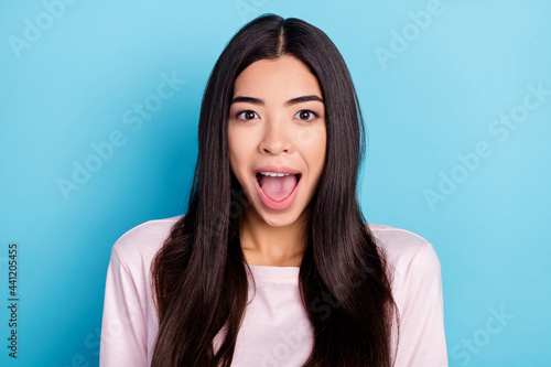 Photo of young excited girl amazed shocked surprised om wow news sale isolated over blue color background