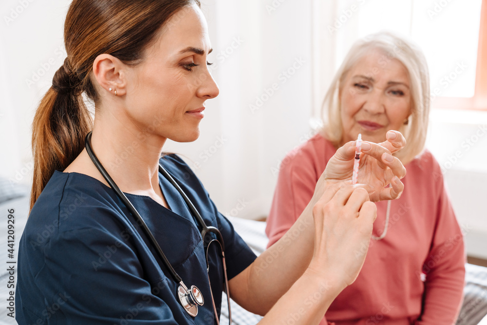 A female doctor wants to give insulin injection to her elderly patient