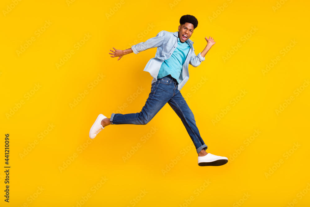 Fototapeta premium Full length body size view of attractive funny cheerful guy jumping running good mood isolated over bright yellow color background