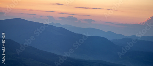 Panorama, smoky silhouette of the Carpathian mountains at sunset © onyx124