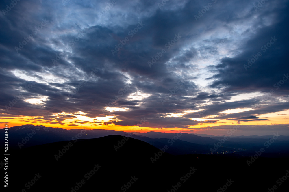 Beautiful multicolored sunset in the Carpathian mountains in summer. Evening landscape