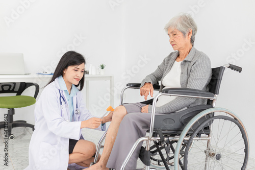 smart asian female doctor use hammer jerk hit to knee of patient, she assess knee symptom of patient ,elderly rehabilitation clinic, they training to rehab muscle, replacement of knee osteoarthritis