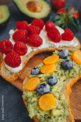 Breakfast  Croissant sandwiches with berries and avocado  Close up  Selective focus  Delicious summer food  Top view on a dark background