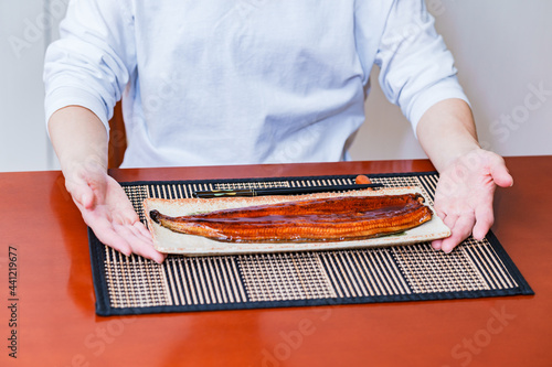 senior Japanese eats grilled Unagi photo