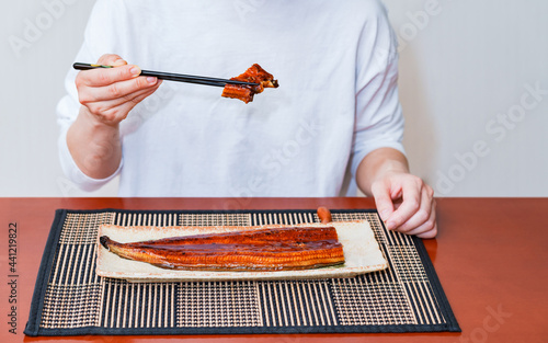 senior Japanese eats grilled Unagi photo