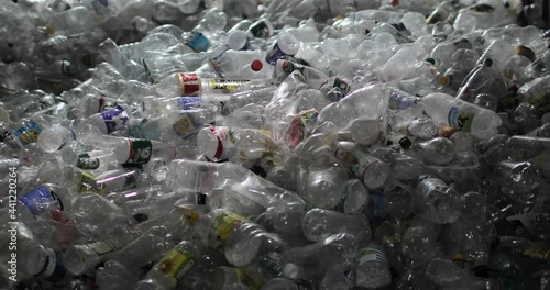 Plastic bottles with lids and labels sorted from other waste. Close-up. Storage, reuse and recycling. Environmental protection concept.