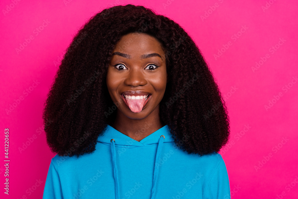 Photo portrait of woman staring showing tongue smiling isolated on vivid pink color background Photo portrait of woman staring showing tongue smiling isolated on vivid pink color background