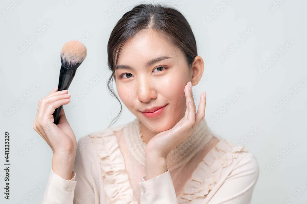 Asian women are applying foundation at the makeup table in the dressing room. Asian women are applying foundation at the makeup table in the dressing room.
