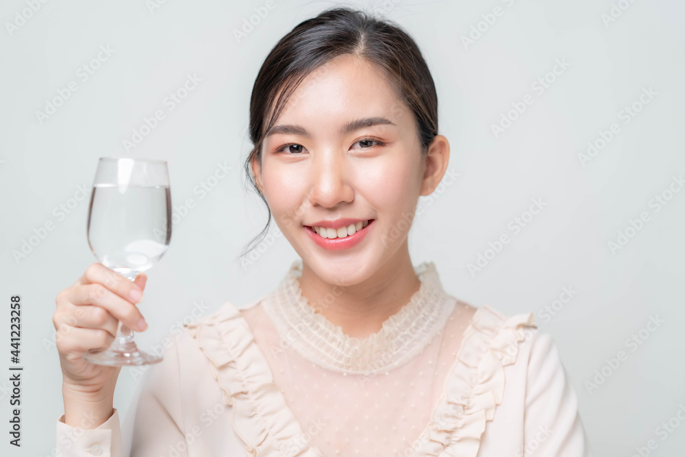 Asian woman drinking clean water on a white background Asian woman drinking clean water on a white background