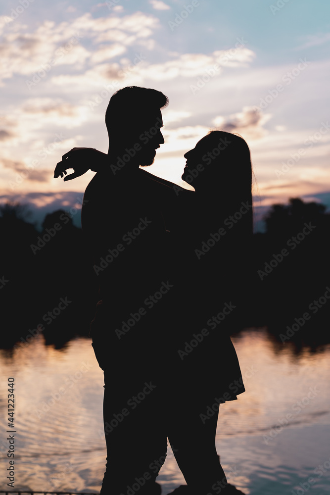 beautiful silhouette of a couple with the sunset in the background