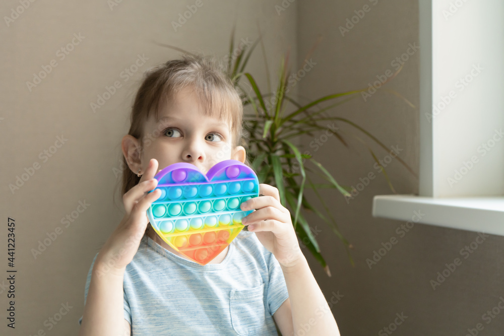 little girl playing with Pop it toy little girl playing with Pop it toy