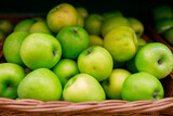 juicy green apples lie in a basket on the counter of the store