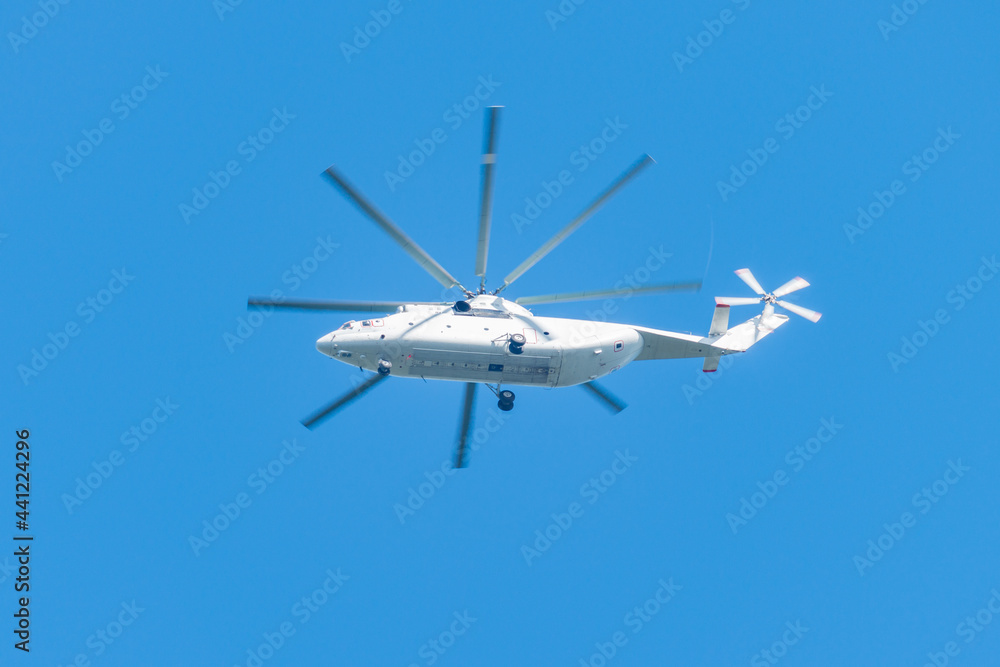 White transport helicopter flying in the sky.