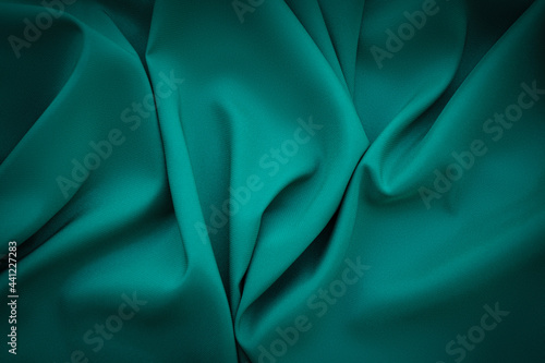 Elegant soft abstract dark green background. Delicate silk waved fabric with copy space for design projects photo