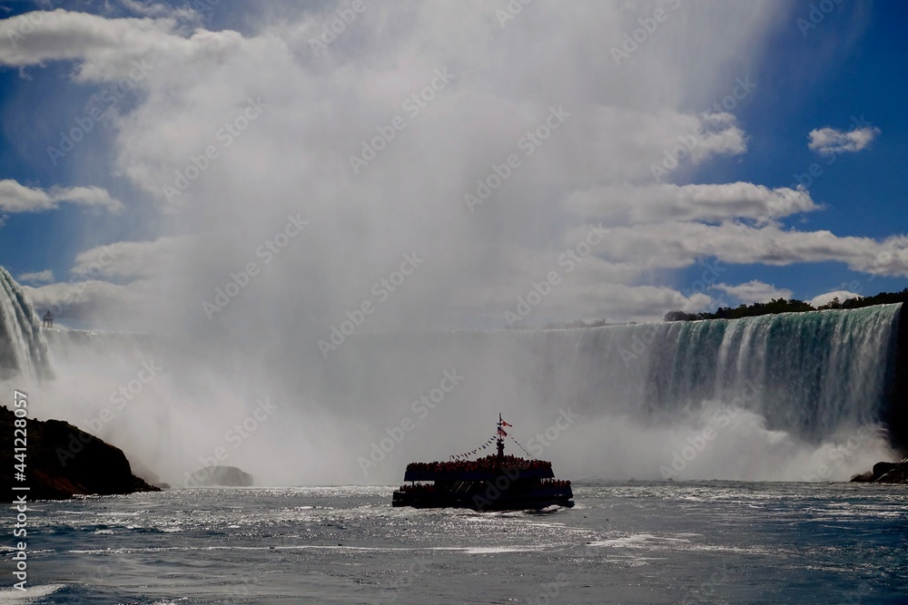 A tour boat from Canada enters the mist of water at the base of Niagara Falls for a close up view.