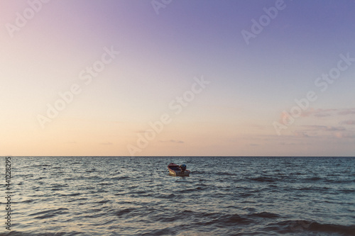 Small boat isolated on the sea on colorful sunset. Concept of lonely. © Sevendeman