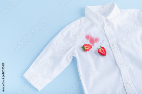Dirty stain of strawberry on a white shirt. daily life dirty stain. Isolated on a blue background