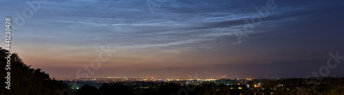 Beautiful panoramic view of very rare noctilucent clouds and stars shining through them seen in Dublin, Ireland on summer solstice of 2021 before midnight. Details of NLC. Night shining panorama
