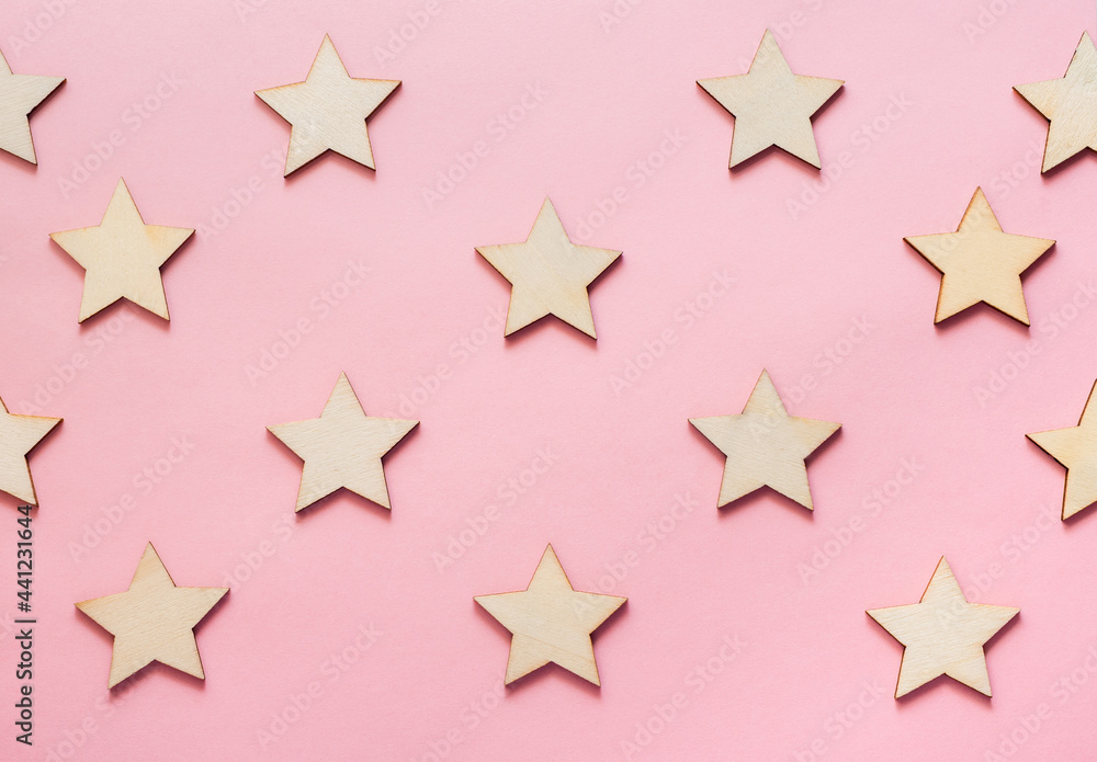 Fototapeta premium Wooden stars on pink background wallpaper