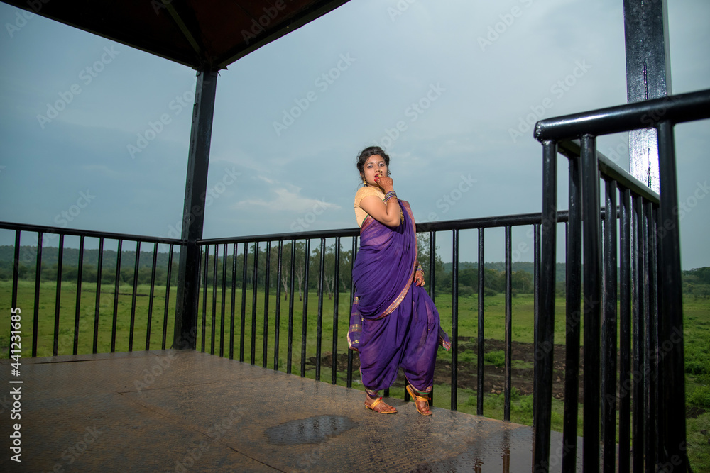 Beautiful Indian young girl in Traditional Saree posing outdoors