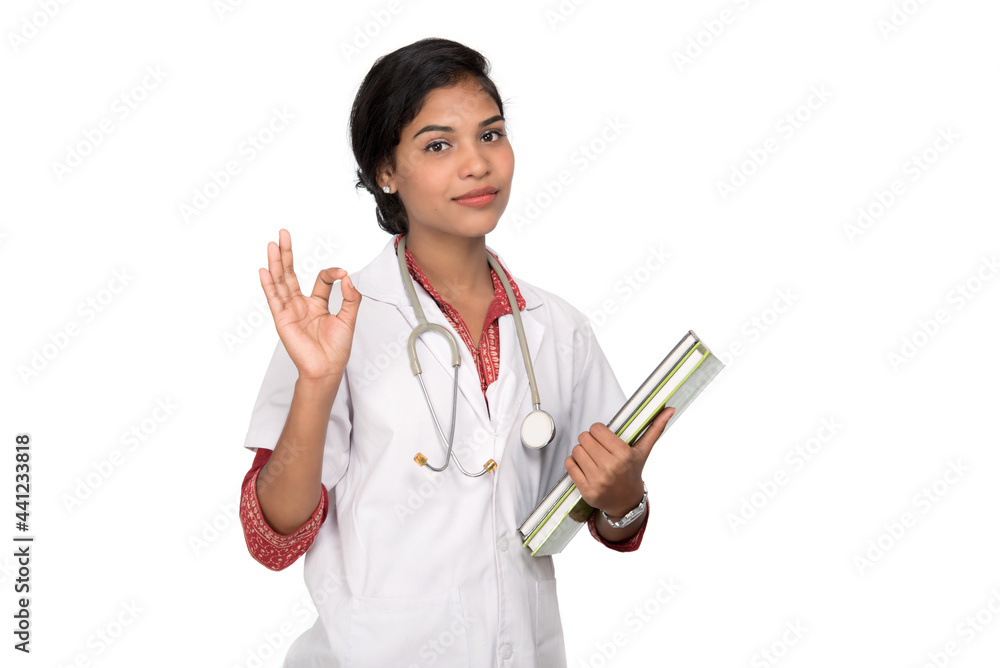 Young woman doctor holding book with stethoscope Young woman doctor holding book with stethoscope