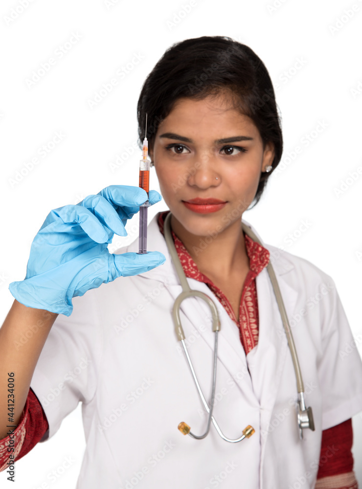 A female doctor with a stethoscope is holding an Injection or Syringe. A female doctor with a stethoscope is holding an Injection or Syringe.