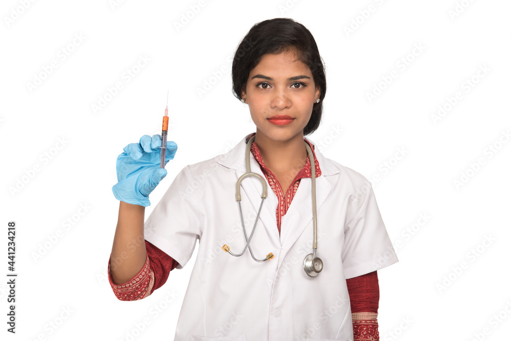 A female doctor with a stethoscope is holding an Injection or Syringe. A female doctor with a stethoscope is holding an Injection or Syringe.