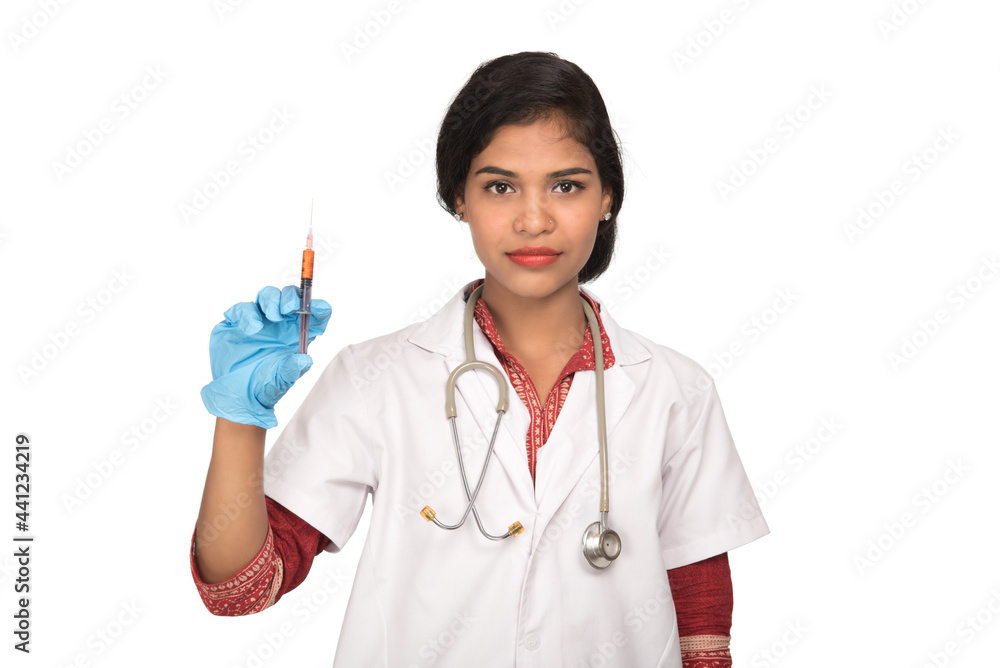 A female doctor with a stethoscope is holding an Injection or Syringe.