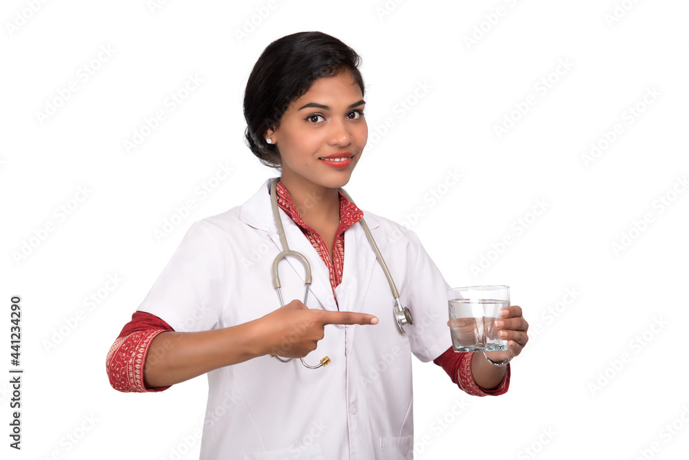 Healthy eating or lifestyle concept: Smiling female doctor holding a glass of clear fresh water Healthy eating or lifestyle concept: Smiling female doctor holding a glass of clear fresh water