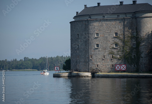 Early sailing boat passes the old Vaxholm fortress in the archipelago of Stockholm