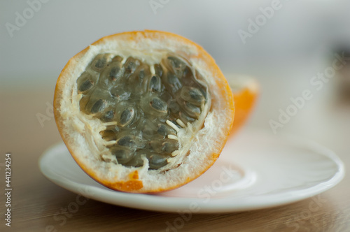 Fresh organic ripe granadilla or yellow passion fruit cut in half on a wooden board. Exotic fruits, healthy eating concept photo