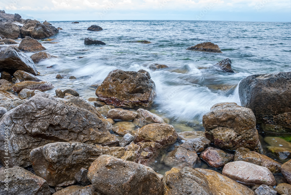 Seascape of the Crimean coast. Waves break into beautiful splashes against rocks.