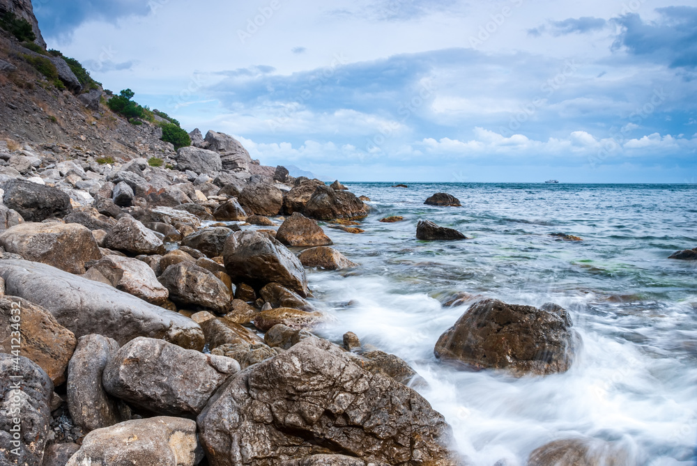 Seascape of the Crimean coast. Waves break into beautiful splashes against rocks.