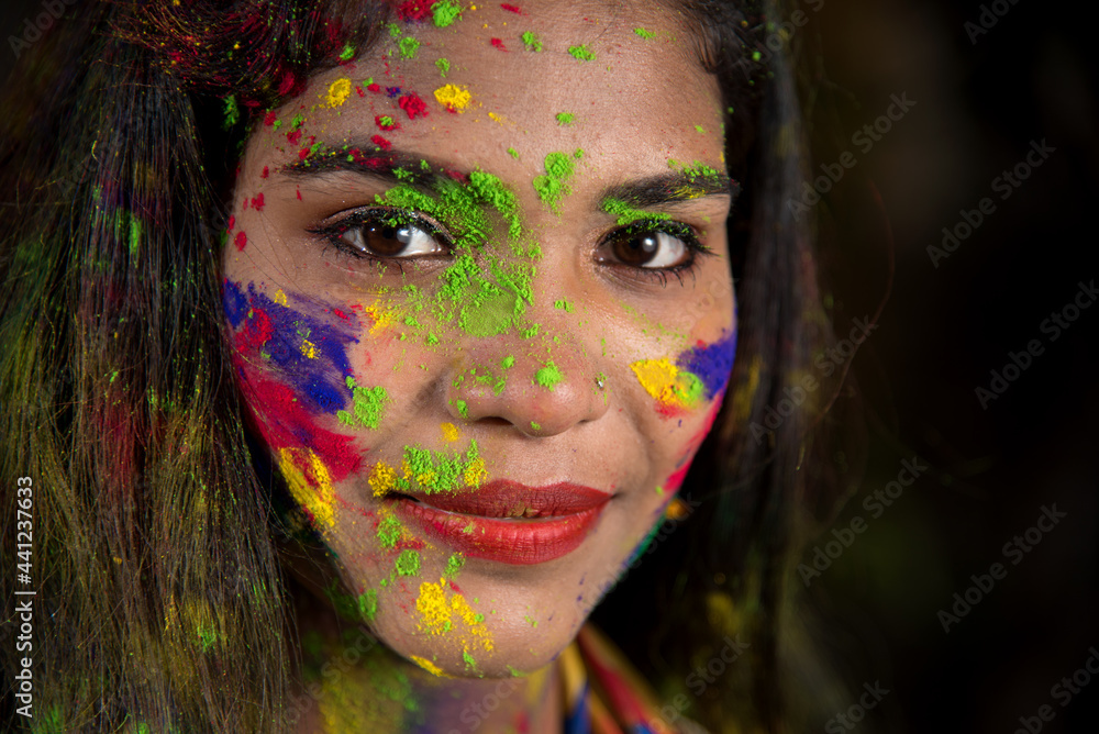 Portrait of a happy young girl with a colorful face on the occasion of Holi color festival. Portrait of a happy young girl with a colorful face on the occasion of Holi color festival.