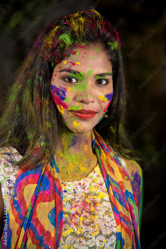 Portrait of a happy young girl with a colorful face on the occasion of Holi color festival. Portrait of a happy young girl with a colorful face on the occasion of Holi color festival.