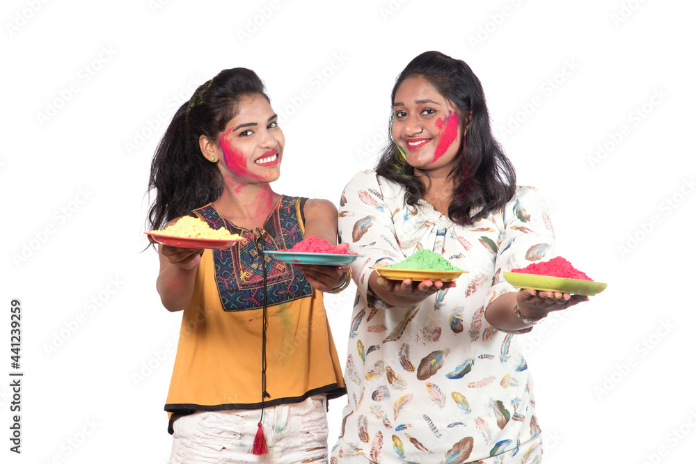 Happy young girls having fun with colorful powder at Holi festival of colors Happy young girls having fun with colorful powder at Holi festival of colors