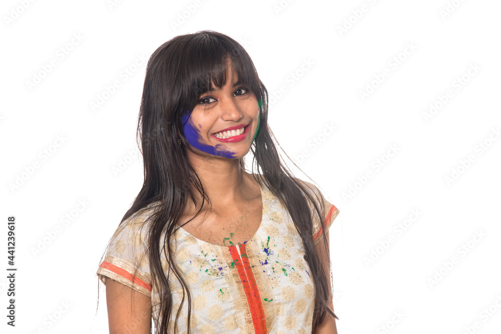 Beautiful young girl posing with colorful face in the occasion of Holi festival on white background. Beautiful young girl posing with colorful face in the occasion of Holi festival on white background.
