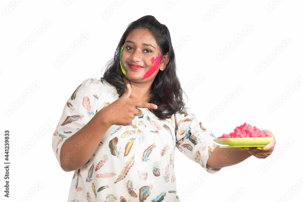 Beautiful young girl holding powdered color in plate on the occasion of Holi festival. Beautiful young girl holding powdered color in plate on the occasion of Holi festival.