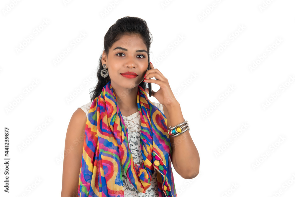 Young Indian girl using a mobile phone or smartphone isolated on a white background Young Indian girl using a mobile phone or smartphone isolated on a white background