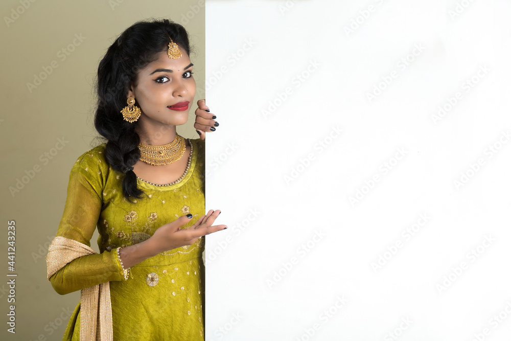 Traditional Girl holding and showing blank white sign board Traditional Girl holding and showing blank white sign board