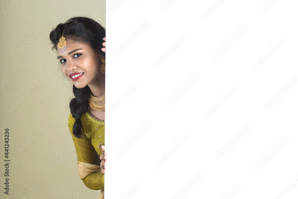 Traditional Girl holding and showing blank white sign board Traditional Girl holding and showing blank white sign board