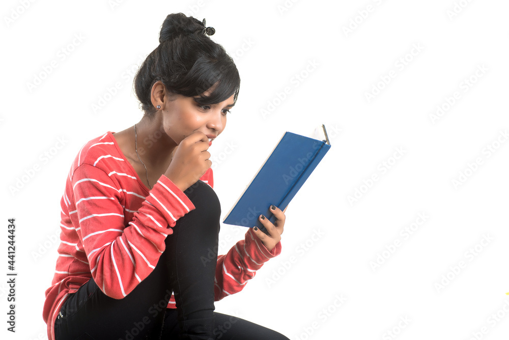 Pretty young girl holding book and posing on white background Pretty young girl holding book and posing on white background