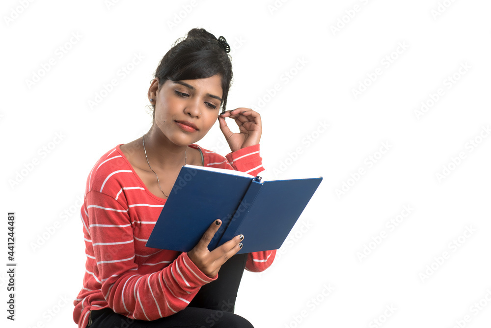 Pretty young girl holding book and posing on white background Pretty young girl holding book and posing on white background