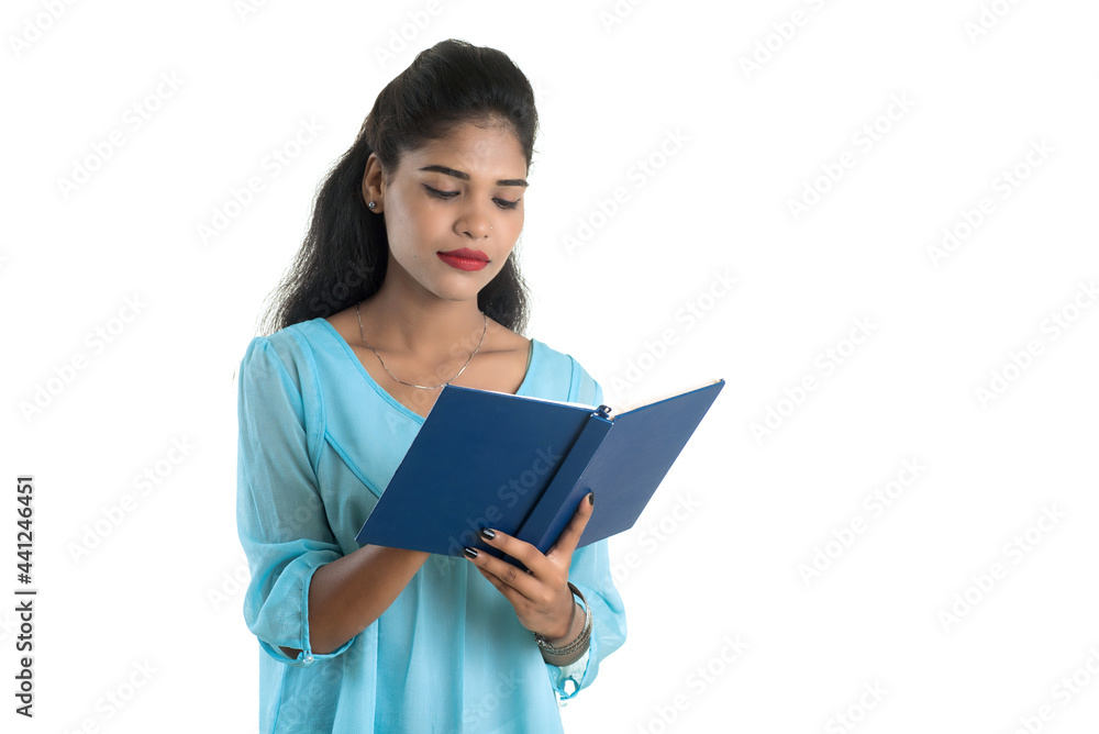 Pretty young girl holding book and posing on white background Pretty young girl holding book and posing on white background